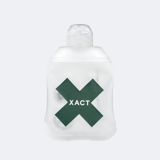A translucent white XACT brand nutrition soft falsk with a dark green X logo and white lettering on the front, set against a light gray background.