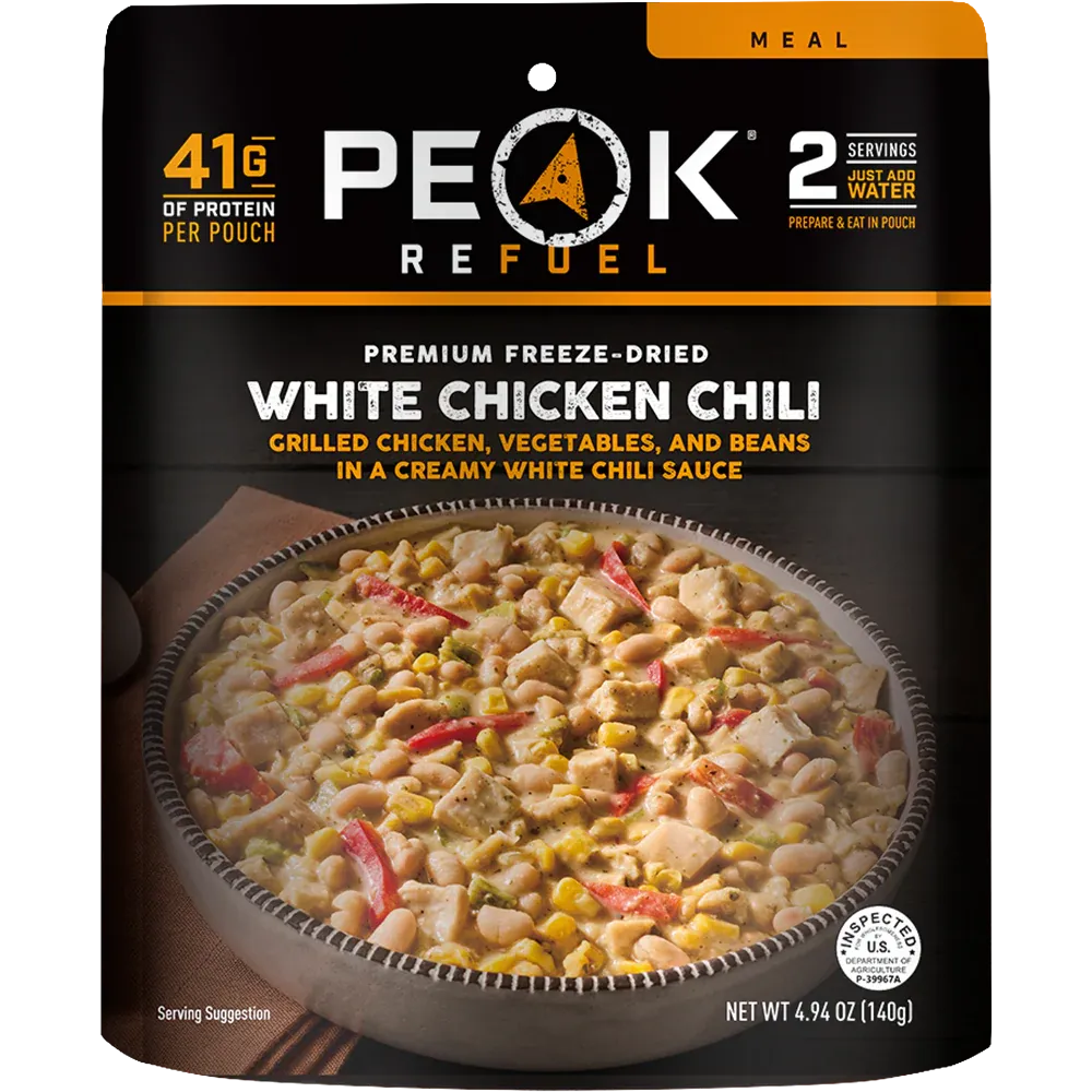 Peak Refuel White Chicken Chili package with a bowl of chili on a black background