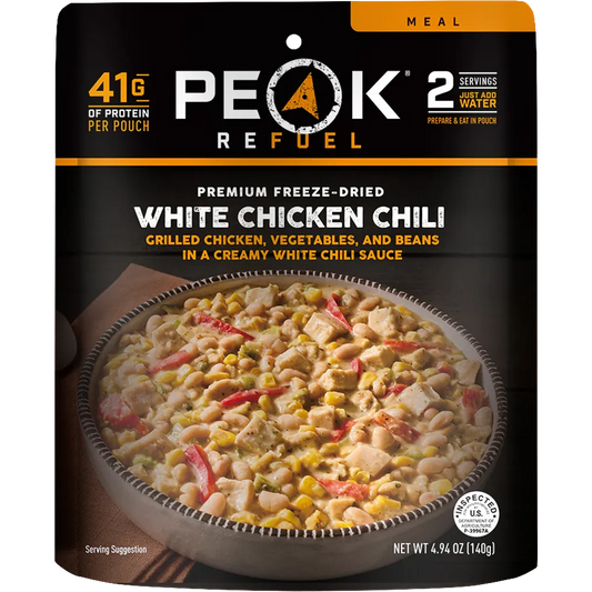 Peak Refuel White Chicken Chili package with a bowl of chili on a black background
