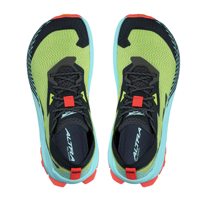 Pair of green and black running shoes with red and blue accents on a white background