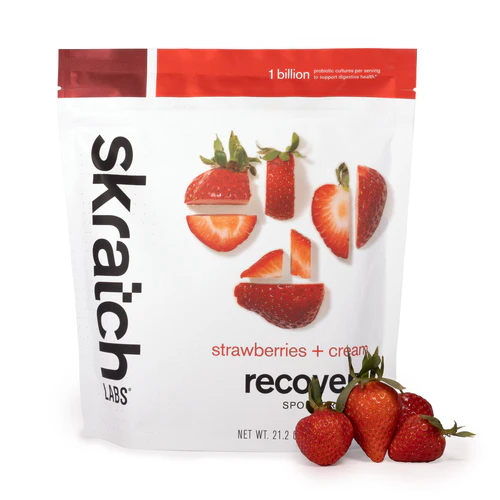Skratch Labs strawberries + cream recovery sports drink package with strawberries on a white background