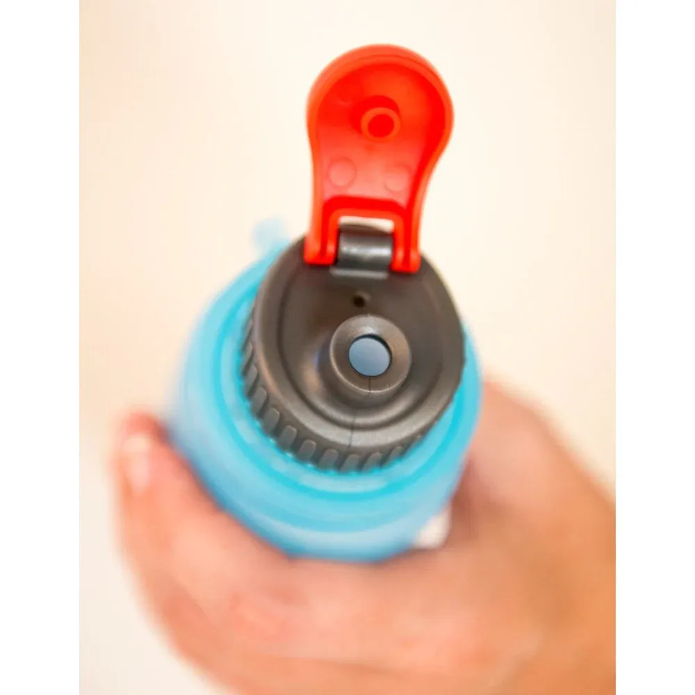 Soft gel flask with with red and blue design held in a hand against a neutral